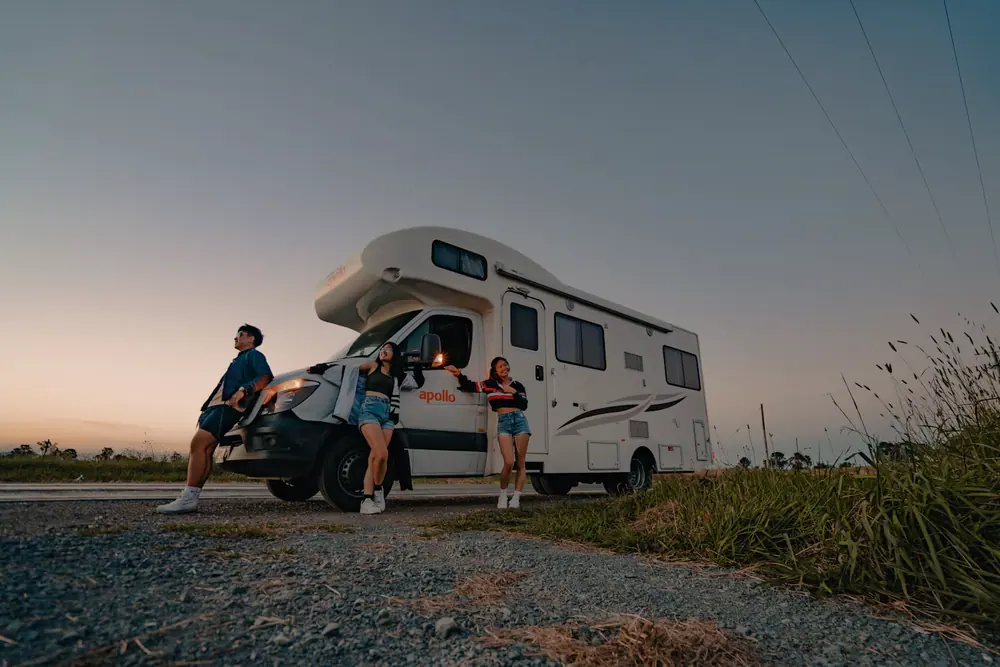 An RV driving along a mountain road at sunset