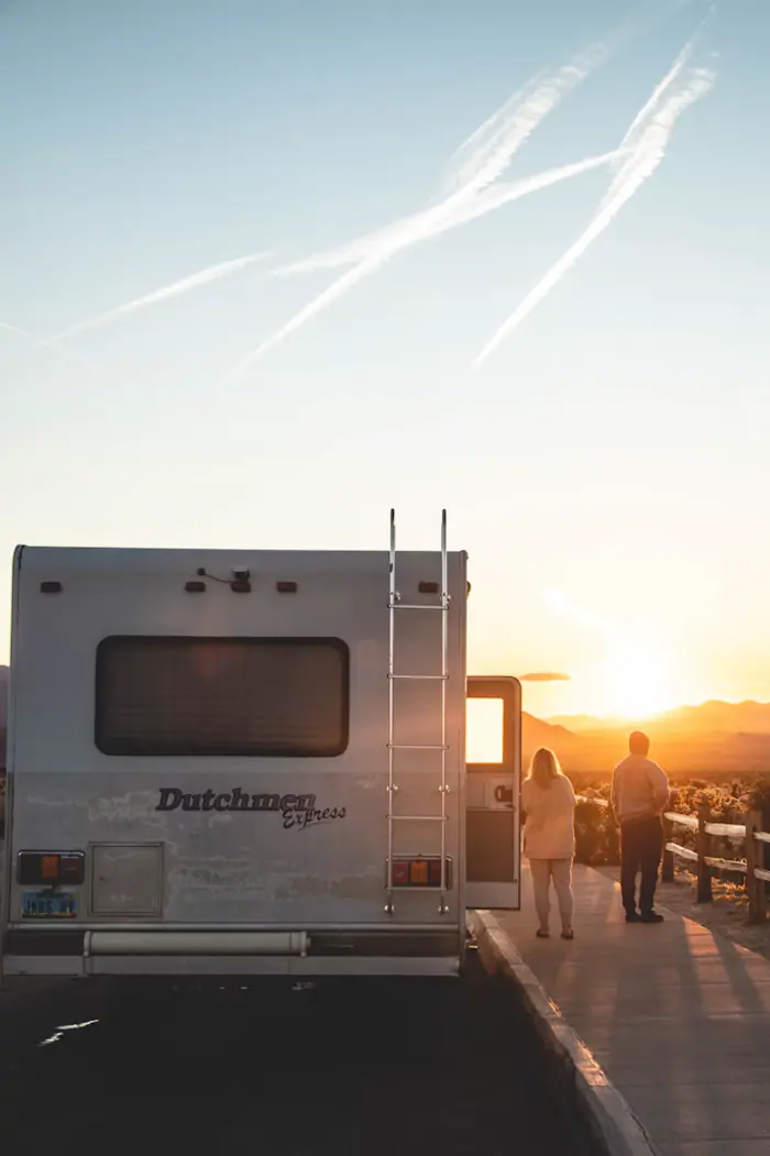 An RV parked beside a mountain lake